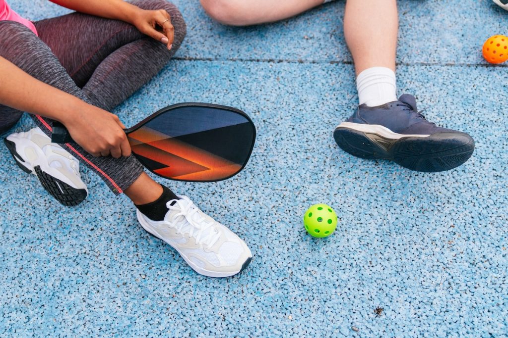 Multiethnic friends preparing to play pickleball at a multi entertainment franchise